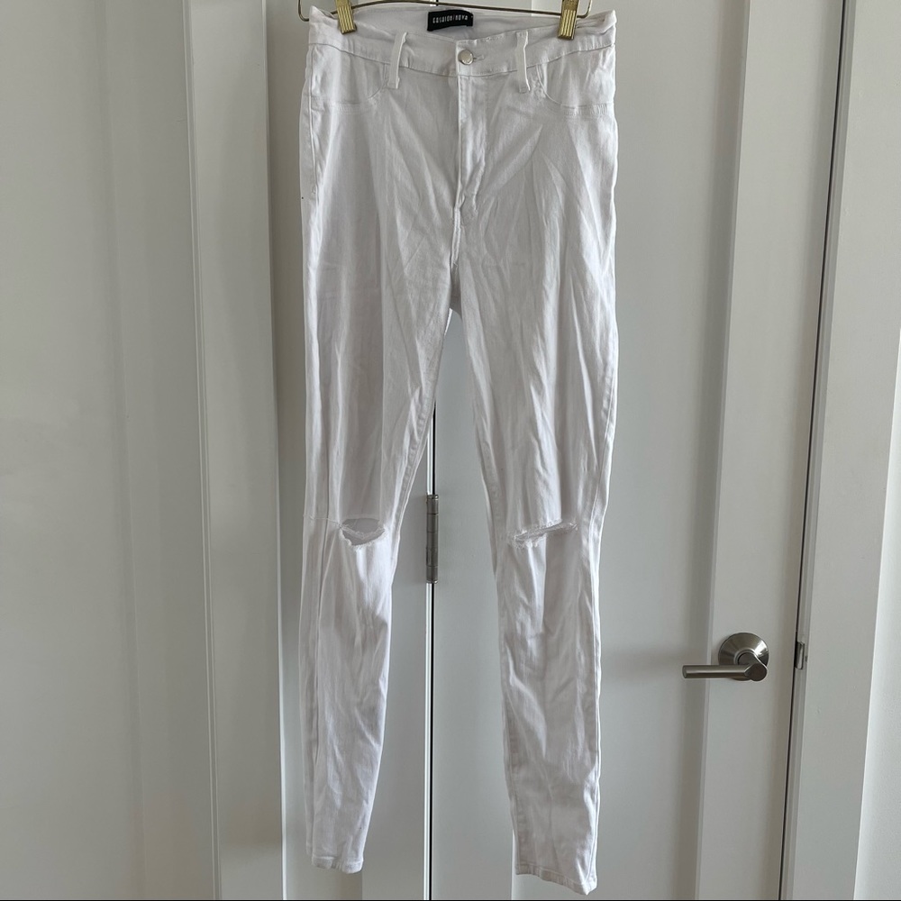 White stretchy skinny denim jeans with distressed rips at knees